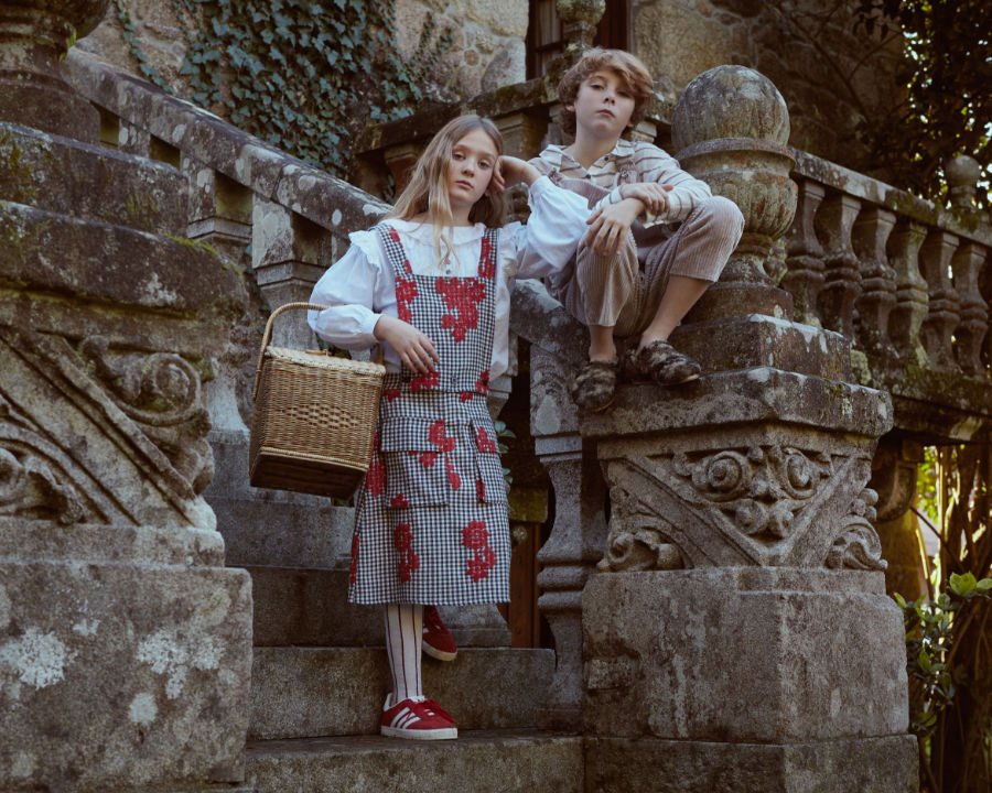 Gretel trägt im Herbst 2018 ein geblümtes Schürzenkleid, Hänsel eine Cord-Dungaree und Fellpantoffeln für die Straße!
