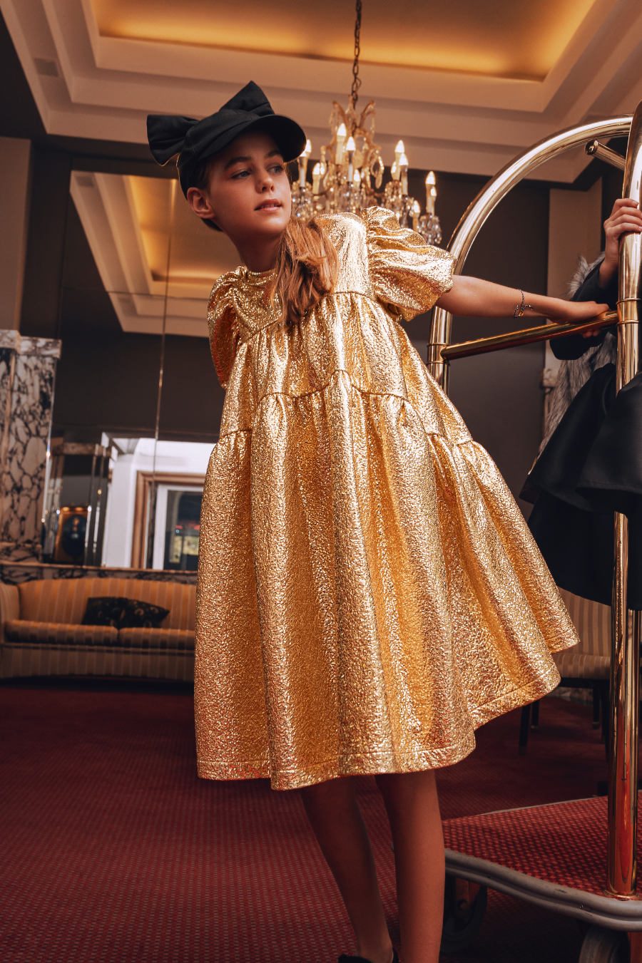 Alma: goldenes Kunstleder-Kleid und Baseball-Cap mit Schleife von CAROLINE BOSMANS, Armband von MAMARADSCHA. Foto © Valentyna Pugachova