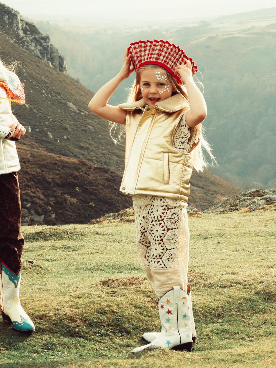 Die Space Cowgirl-Ästhetik der Gen Z trifft auf den Grandmillennial Style: Zur Metallic-Weste trägt Jessica ein Crochet-Ensemble von ROCKFORD & CO