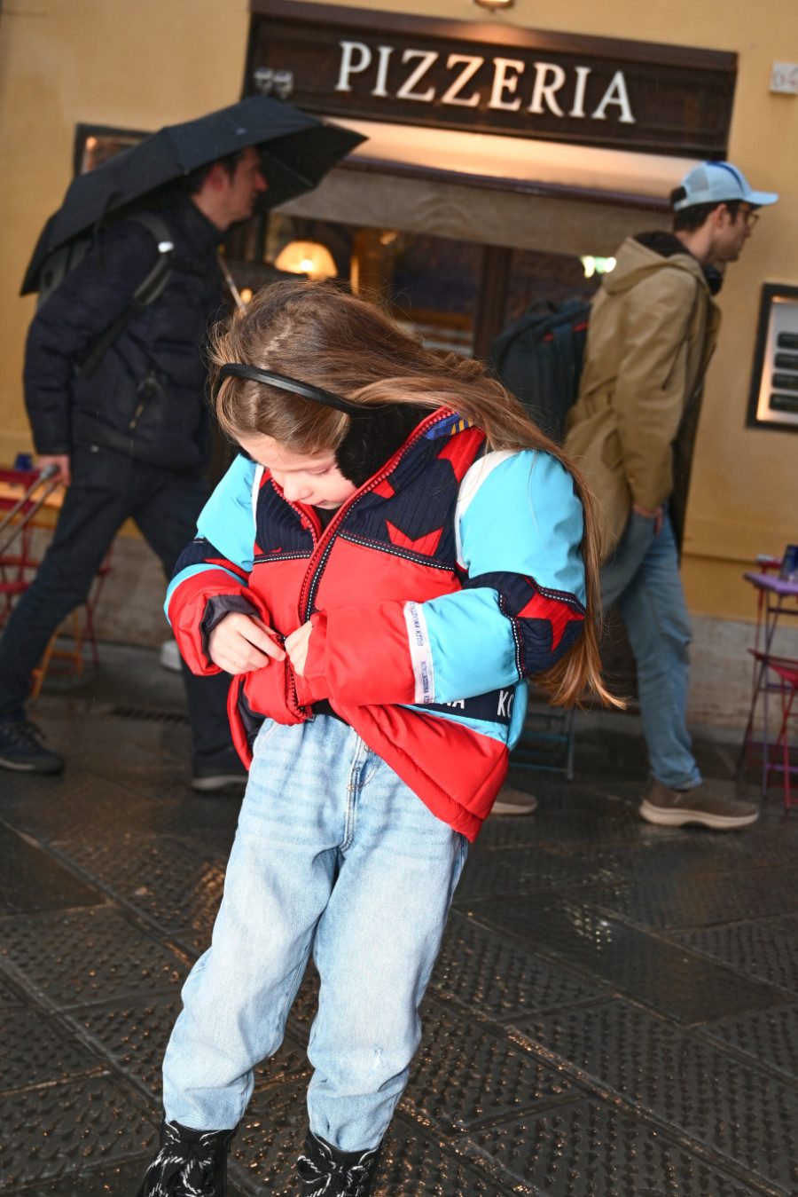 Tschüss Wintertristesse! In einer Patchwork-Pufferjacke von KOMBINIZONA KIDS trotzt Sofia den dunklen Wolken © Valentyna Pugachova