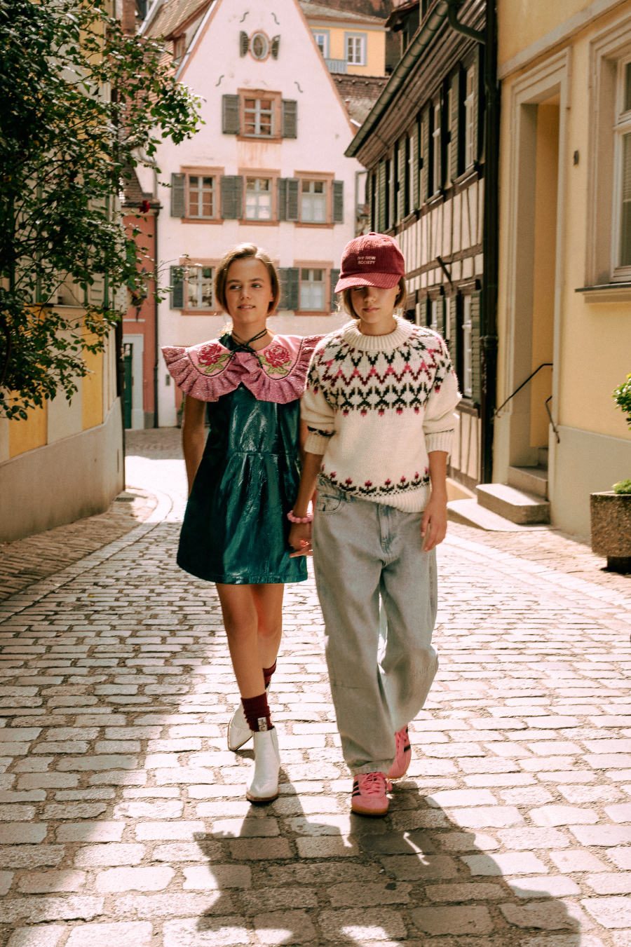 Smilla: Lack-Kleid von BELLEROSE, Kragen von MAEVE CHERRY, Socken von FALKE, Boots von GABRIEL ET VALENTIN. Alma: Pullover und Baseball-Cap von THE NEW SOCIETY, Barrel Pants von REPOSE AMS, Gazelle Sneaker von ADIDAS ORIGINALS, Armband von MAMARADSCHA STUDIO. Foto © Valentyna Pugachova
