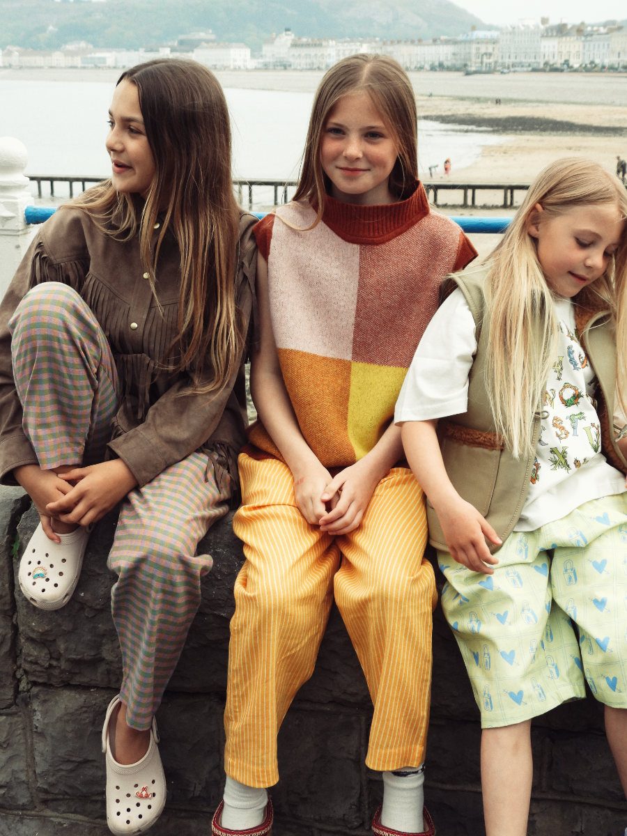 Preya: Leder-Shacket mit Fransen von FILLE GARÇON, Hose von THE KURMA COLLECTIVE, Clogs von CROCS. Sydney: Pullunder von GIANNINA CAPITANI, Hose von THE KURMA COLLECTIVE, Socken von MAIN STORY. Jessica: T-Shirt und Hose von SAUCE MINI, Lederweste von FILLE GARÇON